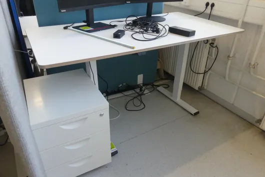 Electrically height-adjustable desk with office chair, without contents
