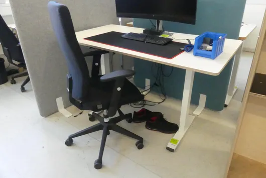 Electrically height-adjustable desk with office chair, without contents
